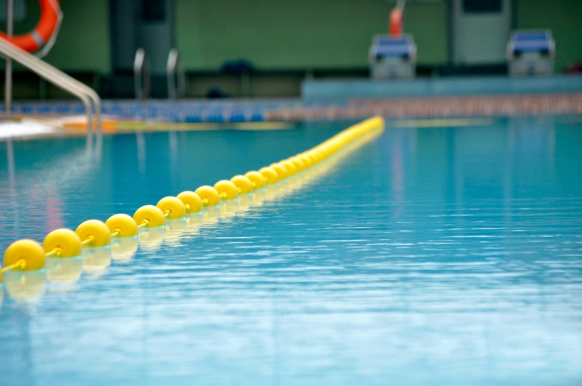 A swimming pool with a yellow rope in the water.