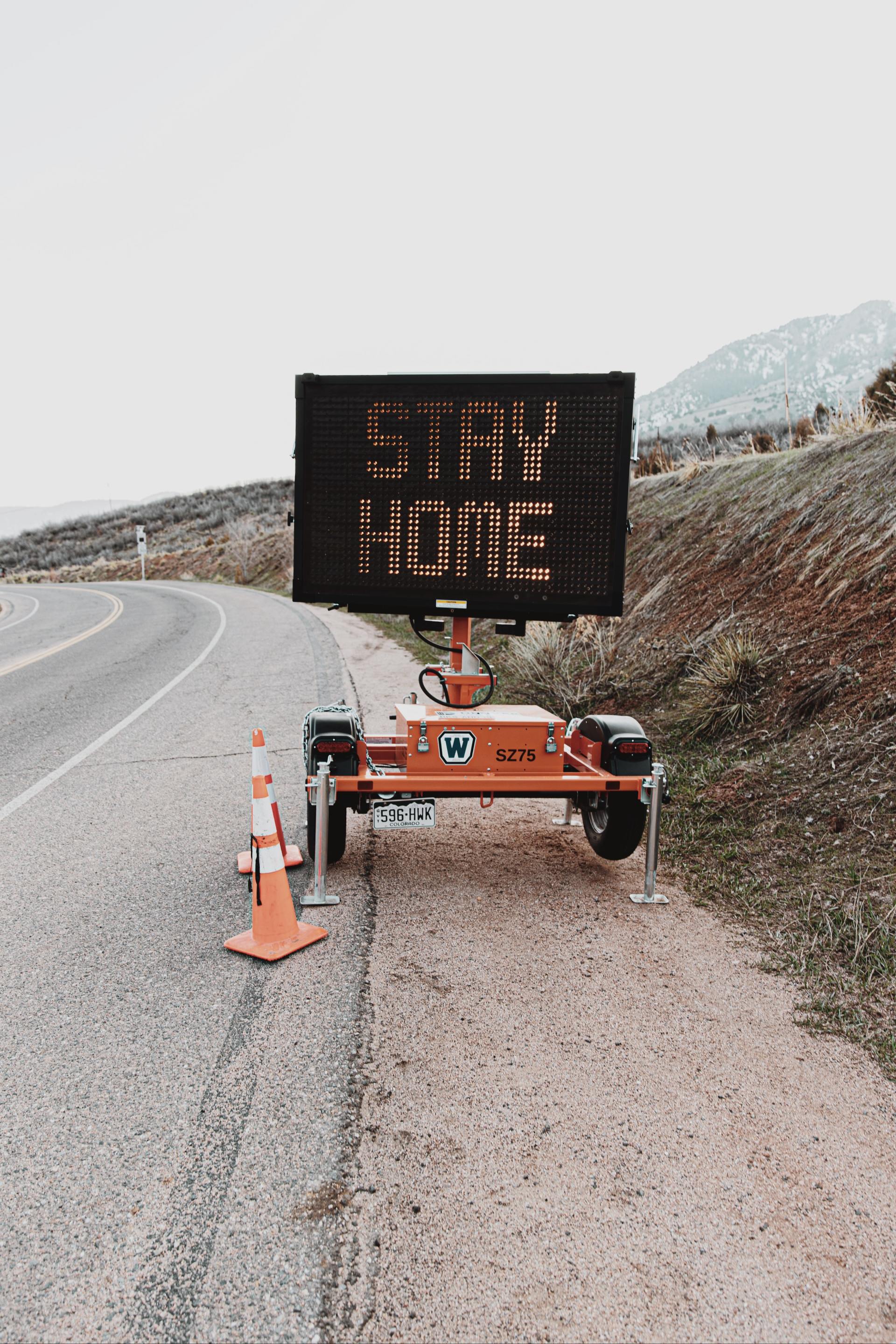 a roadway sign flashing stay home