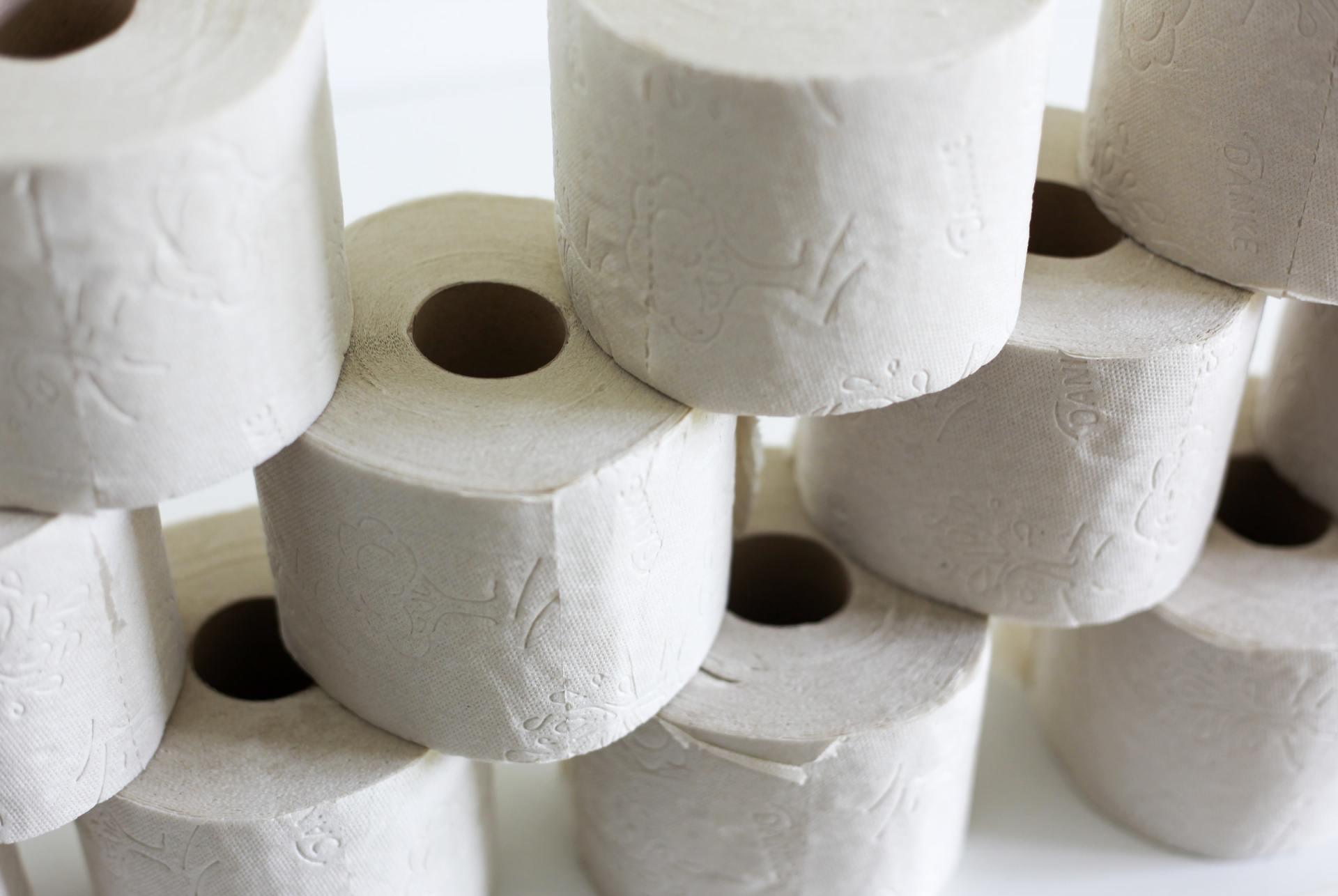 There are many rolls of toilet paper stacked on top of each other.