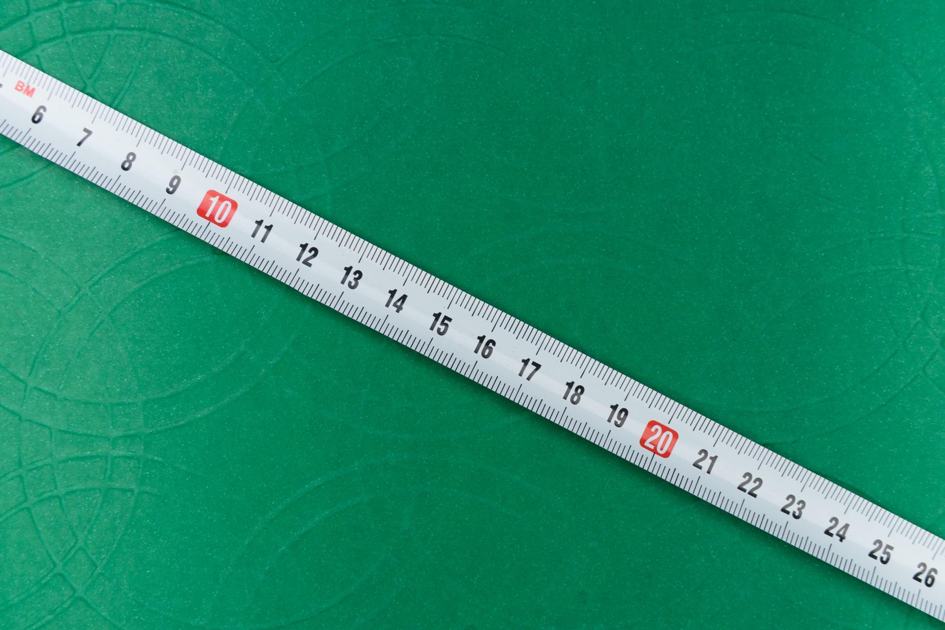 measuring tape on a green textured background