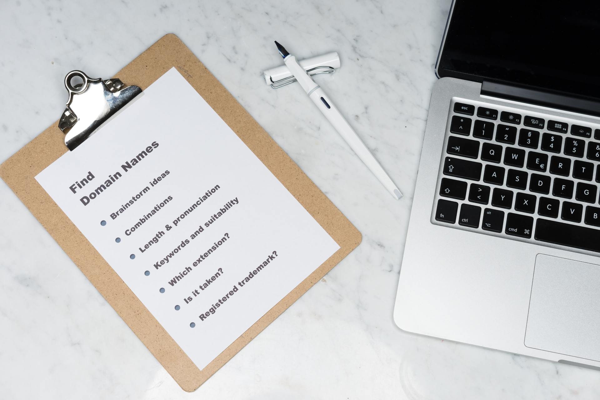 A clipboard with a list of things to do next to a laptop