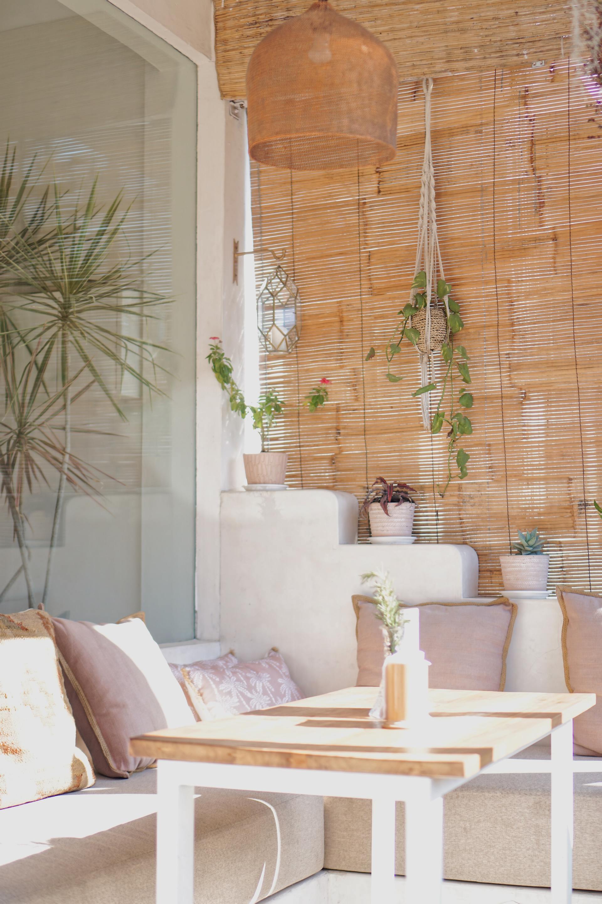 A living room with a wicker wall , tables and chairs.
