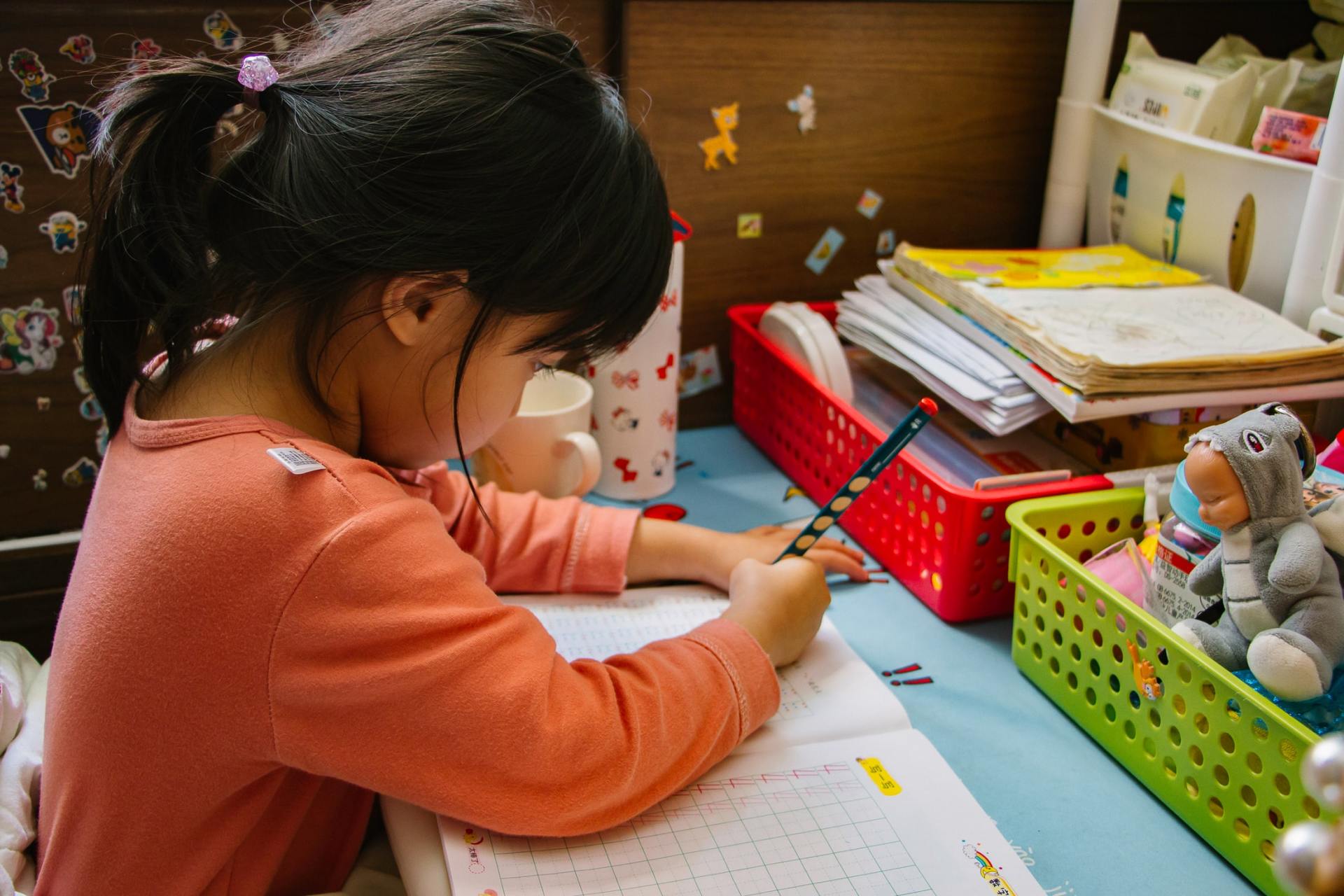 Young kindergarten kid doing her homework