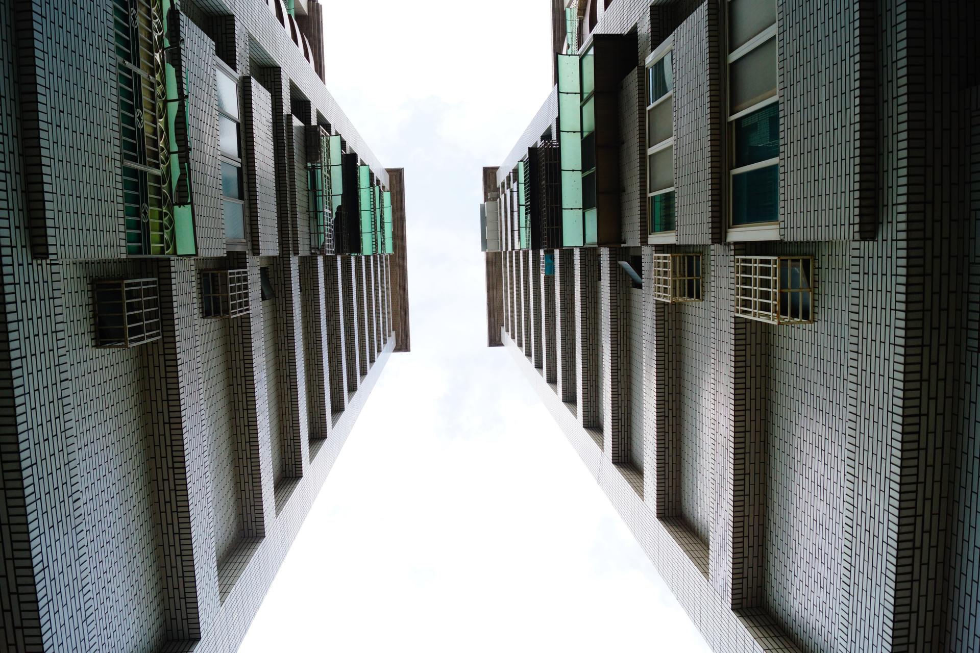 Blicken auf eine Reihe hoher Gebäude mit einem weißen Himmel im Hintergrund.