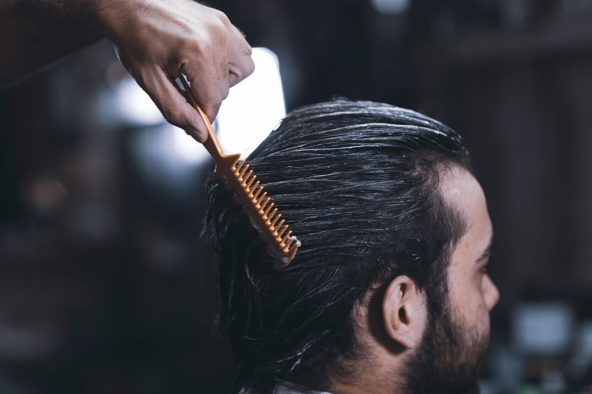 man brushing comb through hair