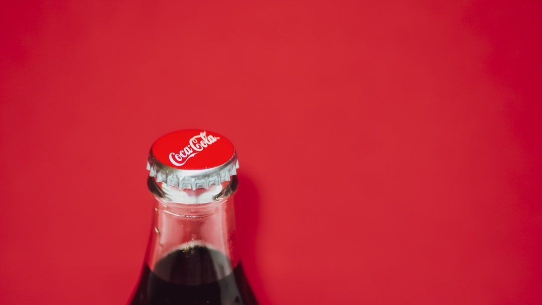 coca cola bottle against a plain red background