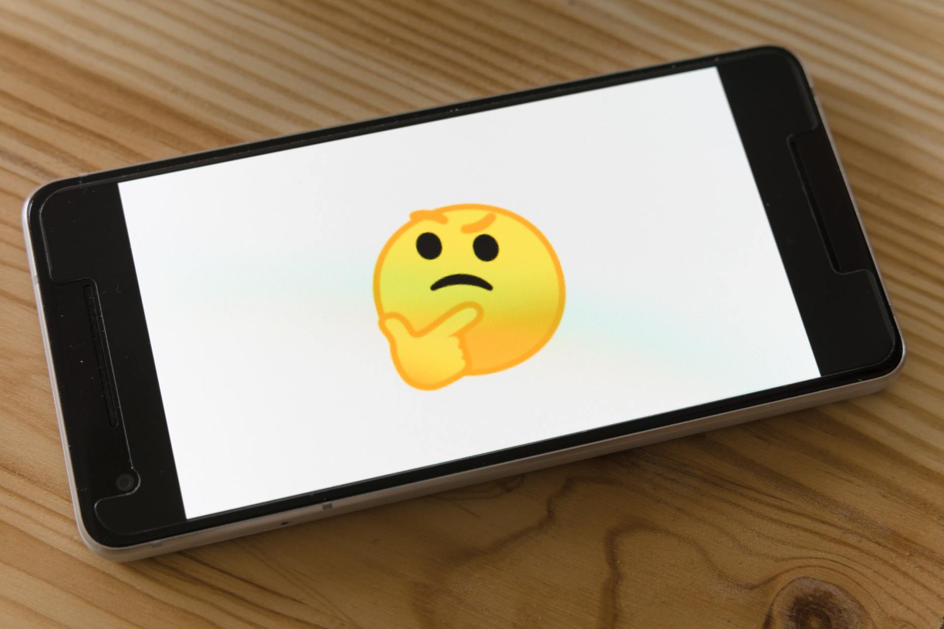 Celular mostrando um emoji pensativo