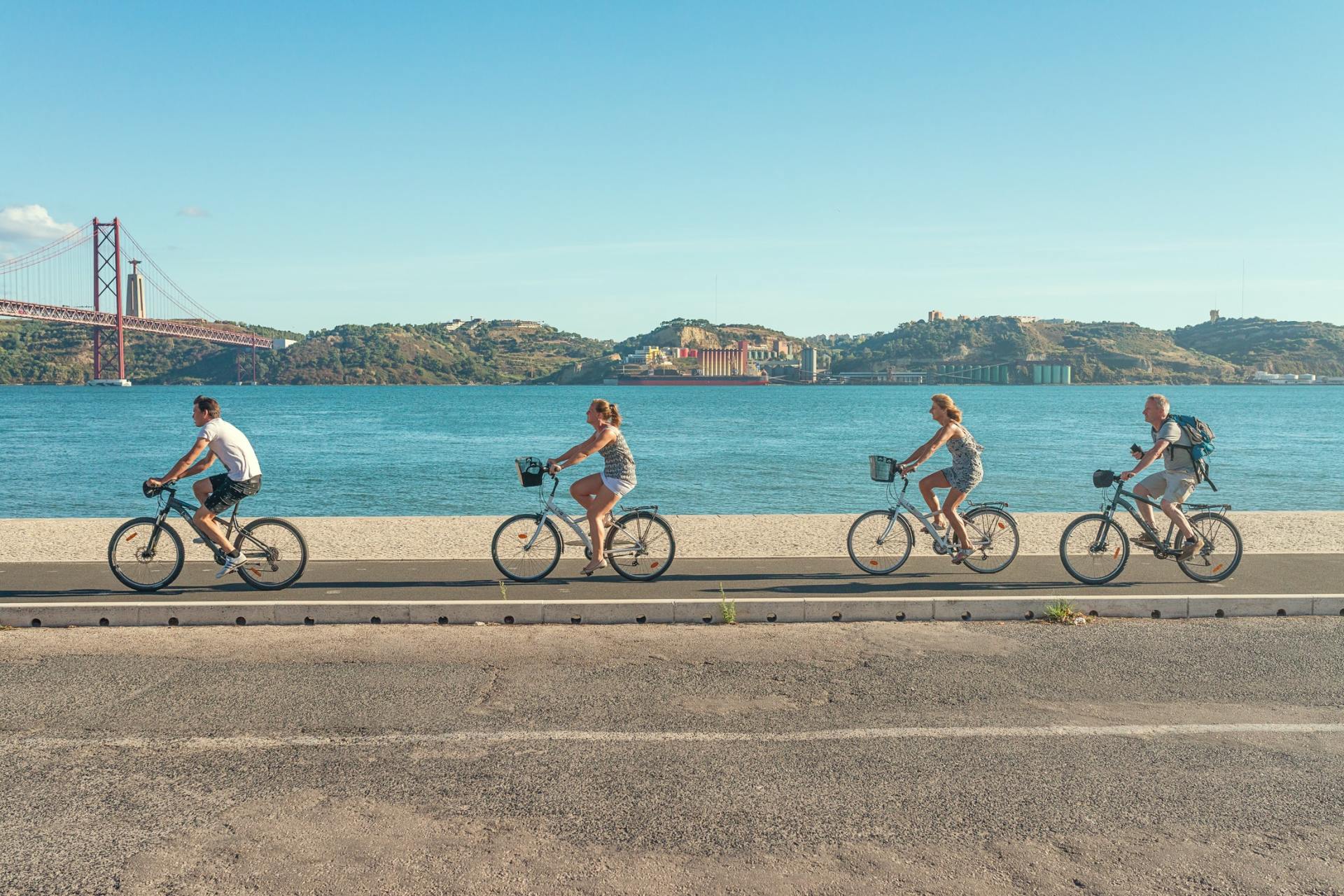 Family riding bikes along sunny beach