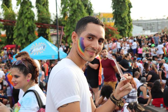 guy with a rainbow on his face smiling looking happy