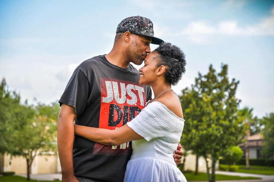 black man kissing forehead of black woman she hugs