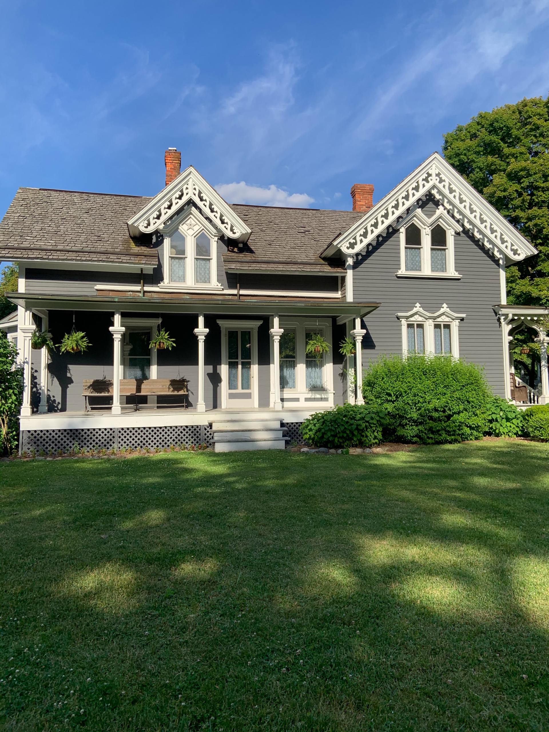 The front yard of a historic Vermont home with well-kept landscaping.
