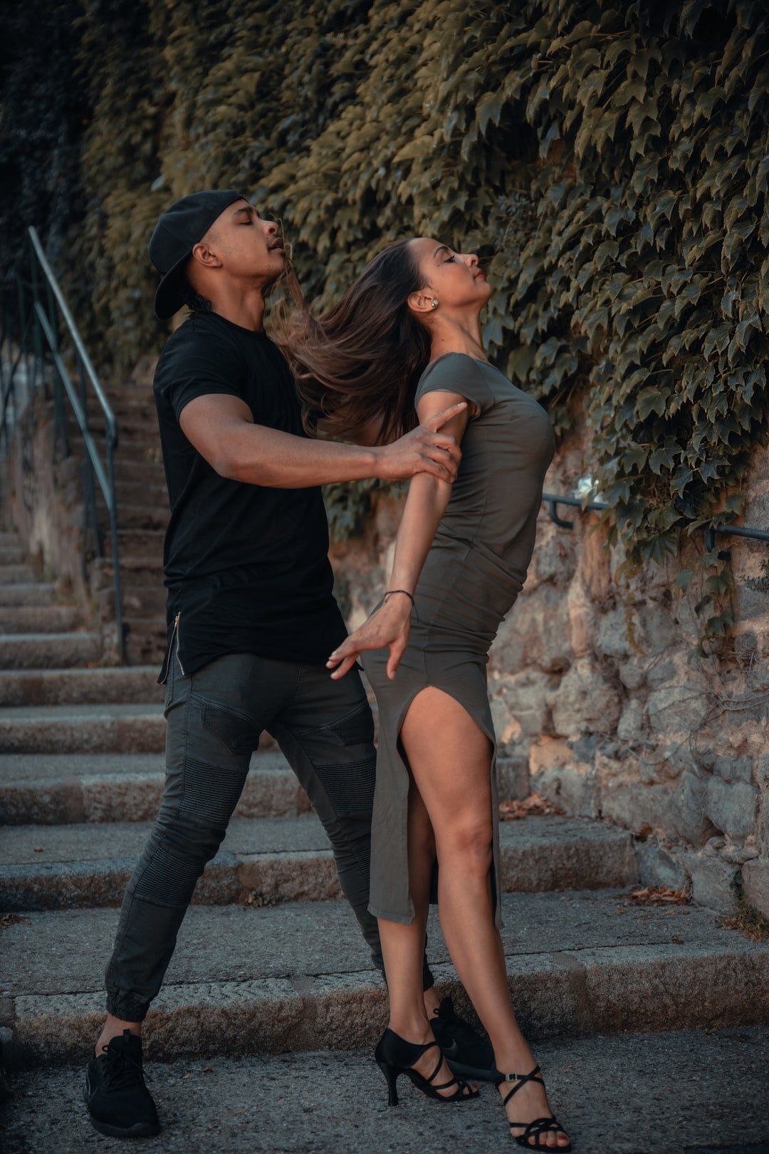 A man and a woman are dancing on a set of stairs.