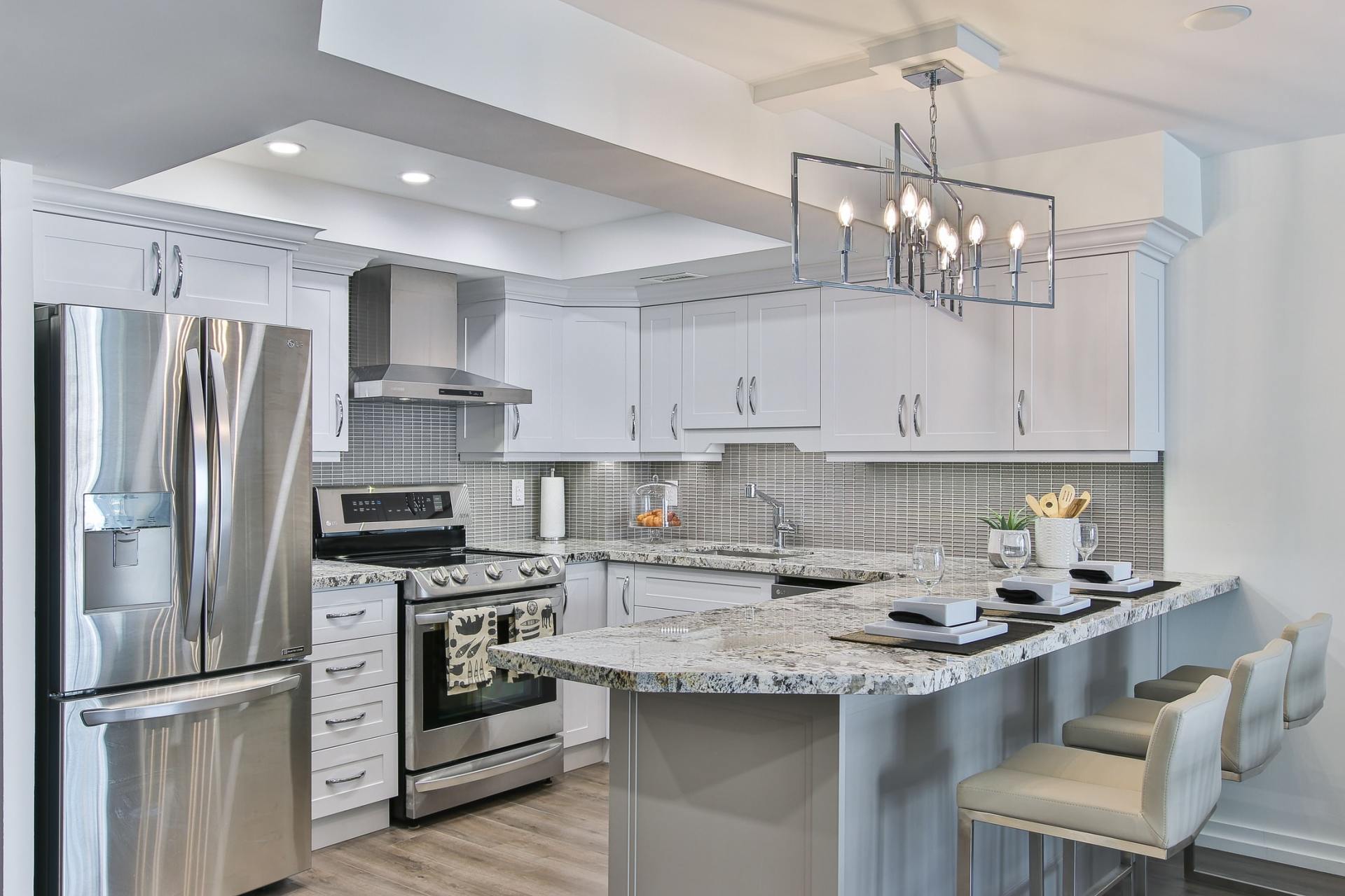 A kitchen with stainless steel appliances and white cabinets.