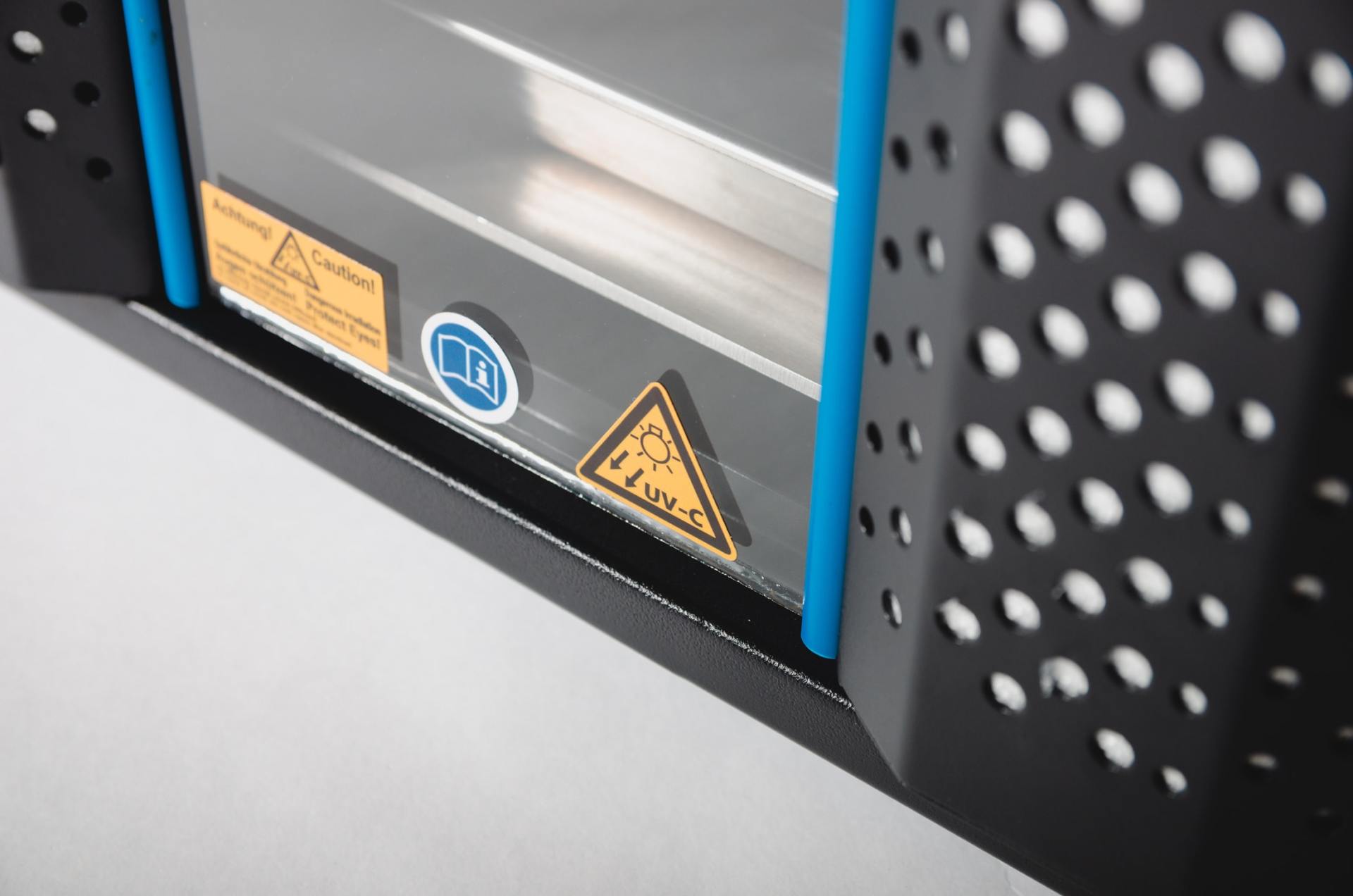 Black and blue industrial machine with warning signs: electrical hazard and general caution.