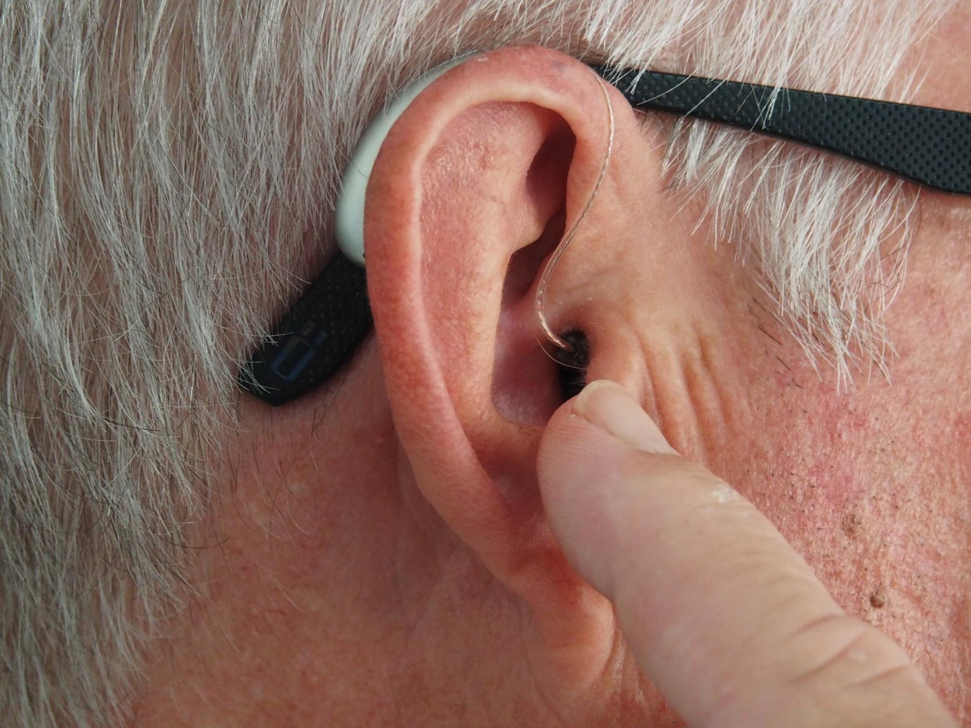 white-haired man with hearing aid in ear