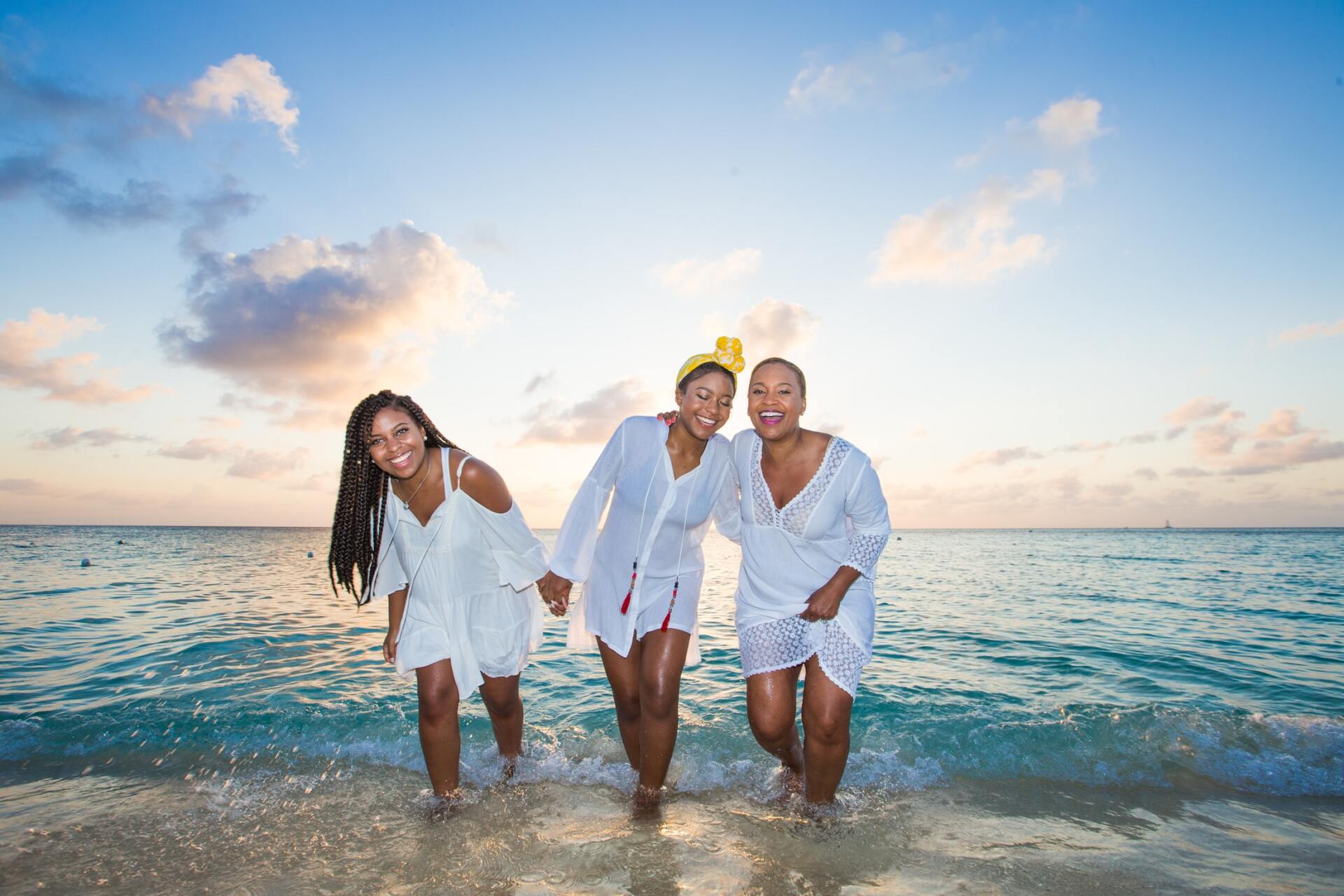 Family walking out of ocean in white bathing suit covers.
