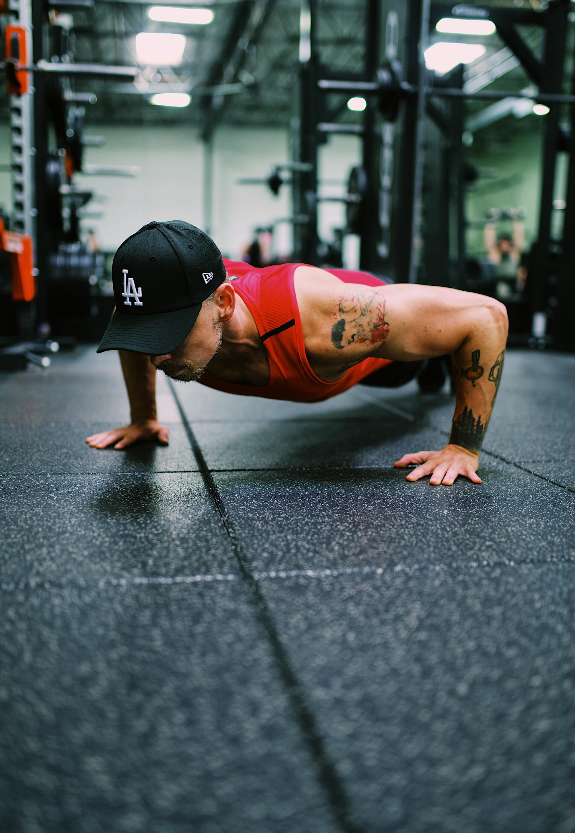 A man is doing push ups on the floor in a gym.