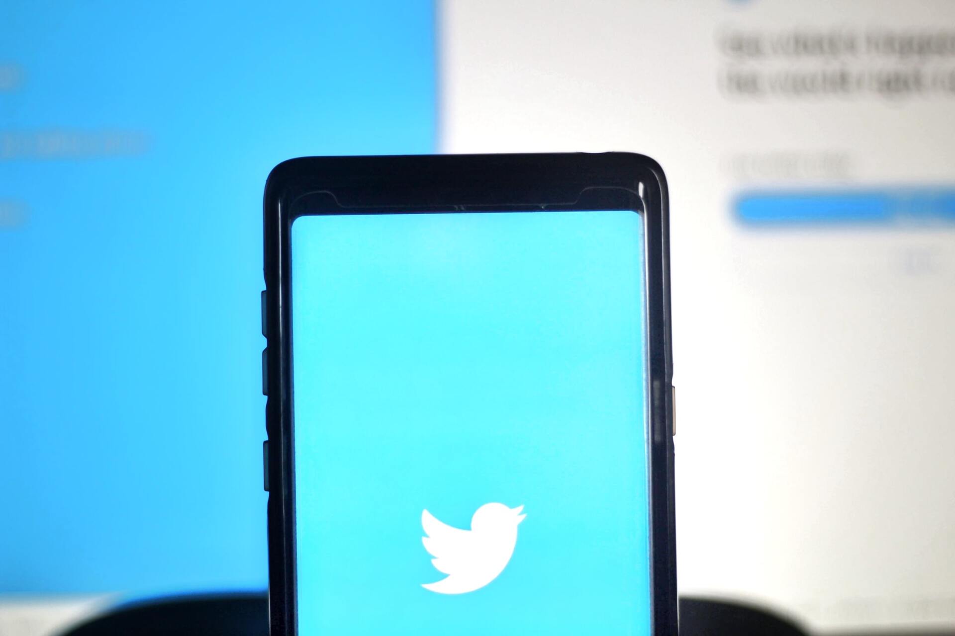 A phone with a twitter logo on the screen