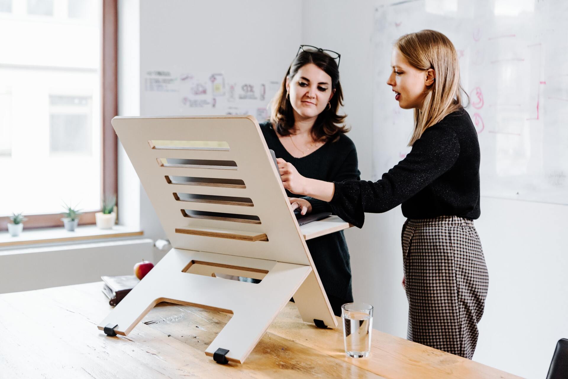 Two women standing at a project management board