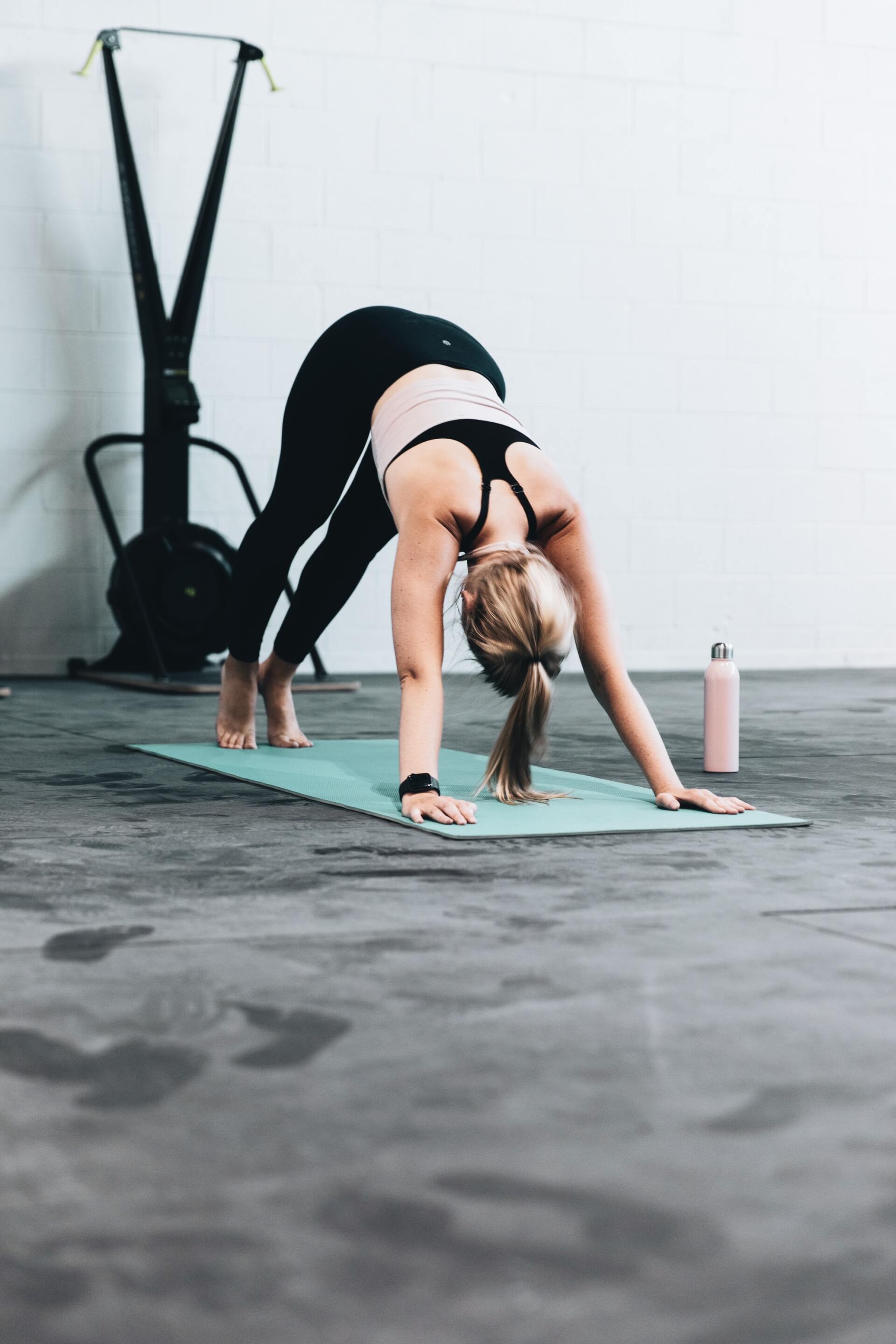 Een vrouw doet een pilates op een yogamat in een sportschool.