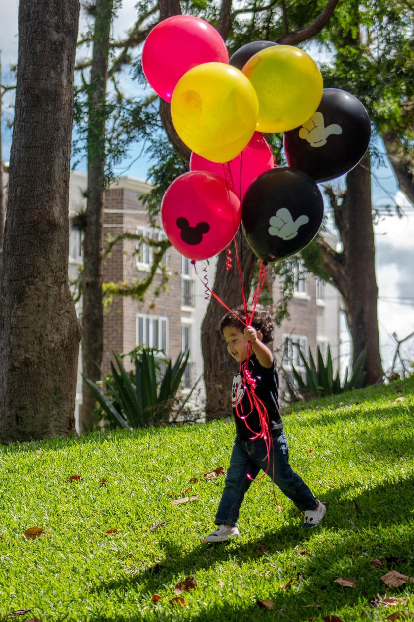 Baby holding disney balloon