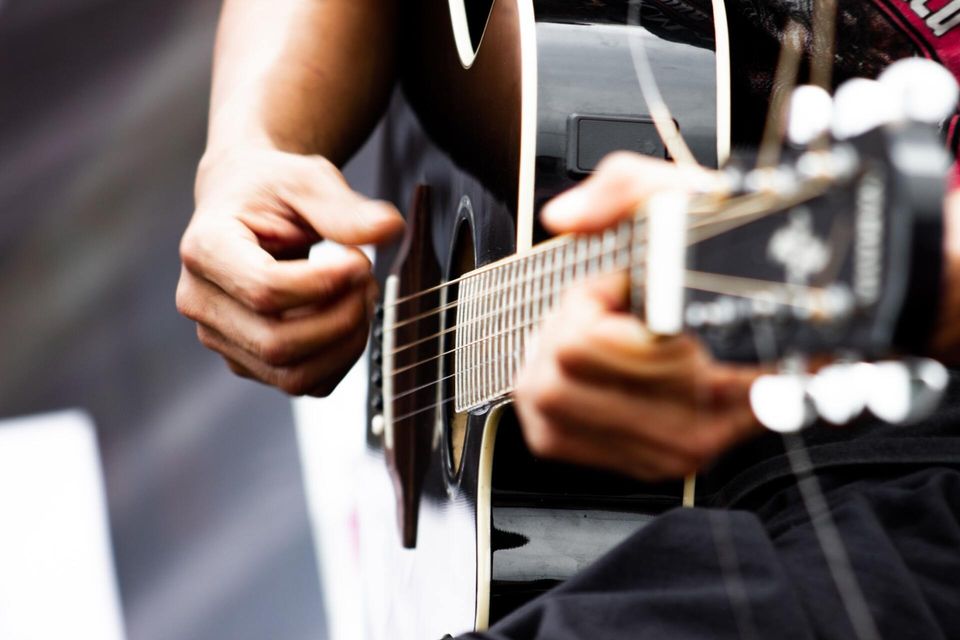 adult hands strumming a guitar