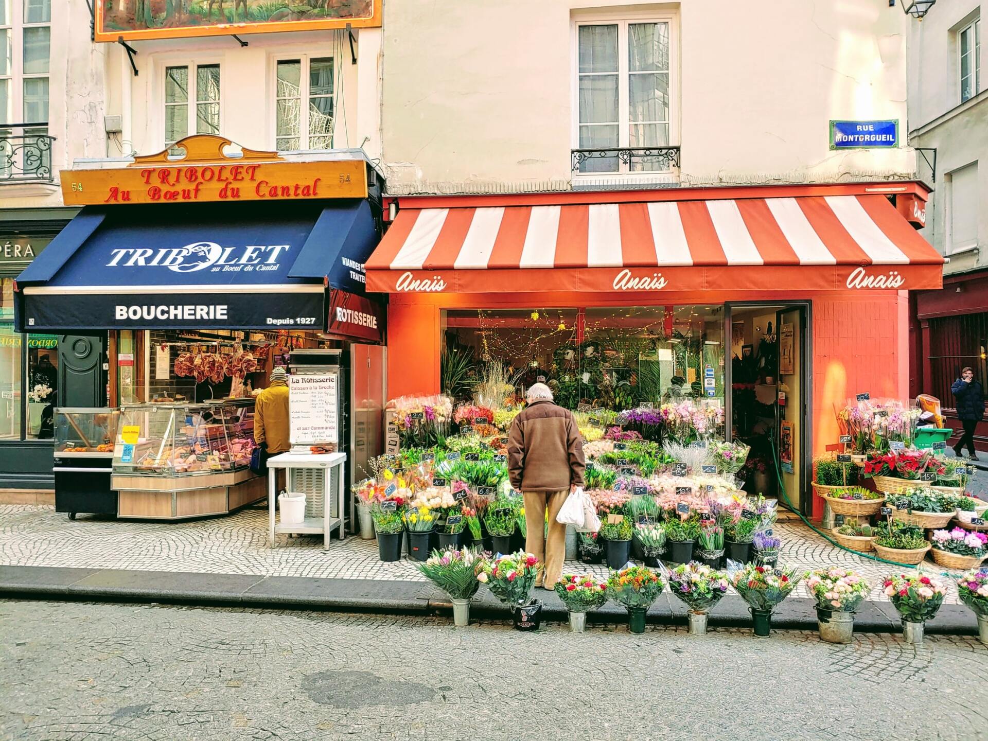 A man is standing in front of a flower shop