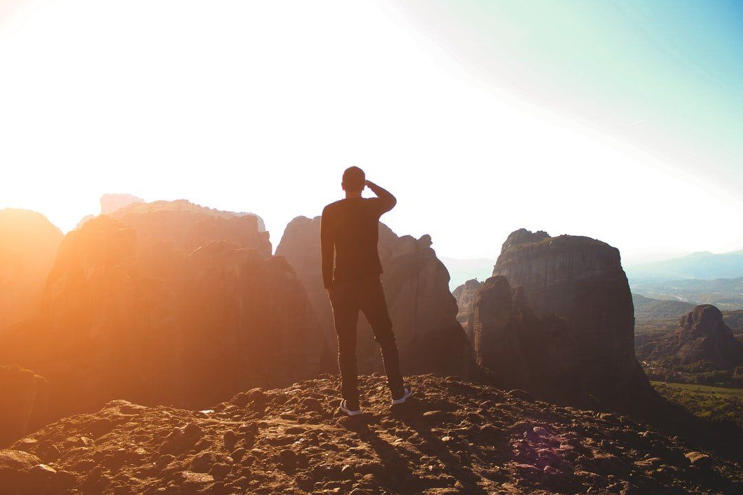 A man standing on top of a rocky mountain