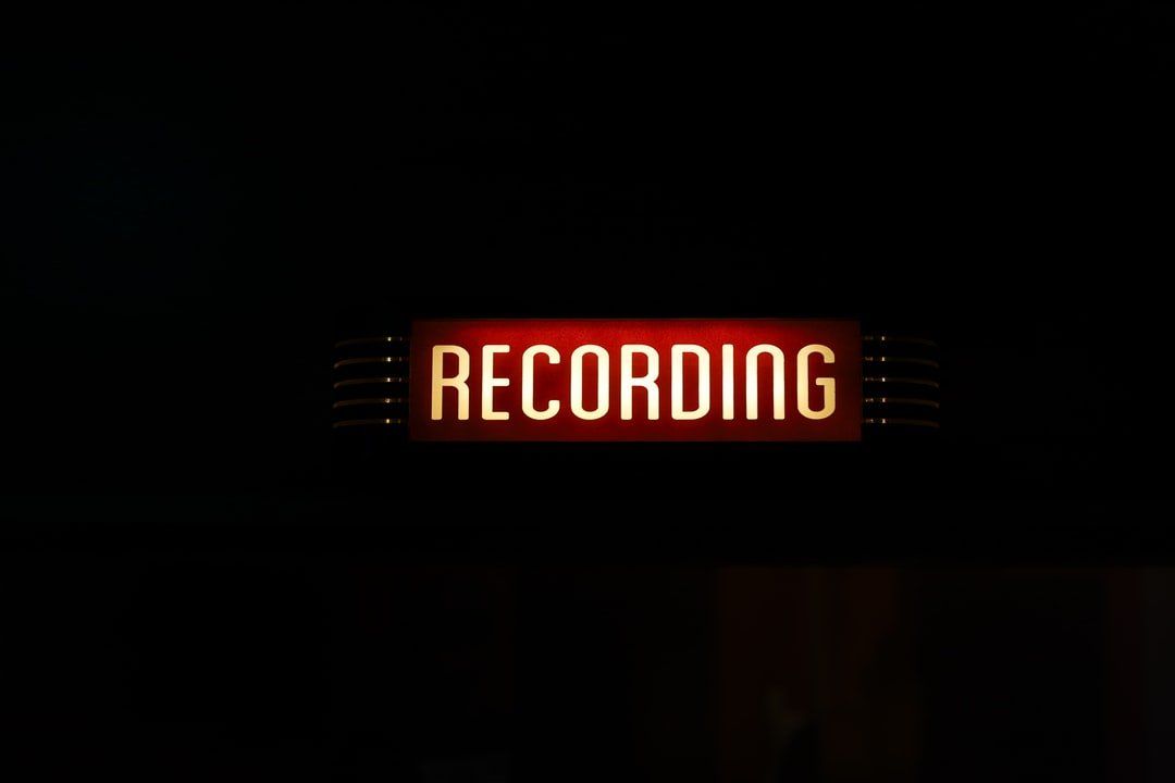 A sign that says recording is lit up in the dark