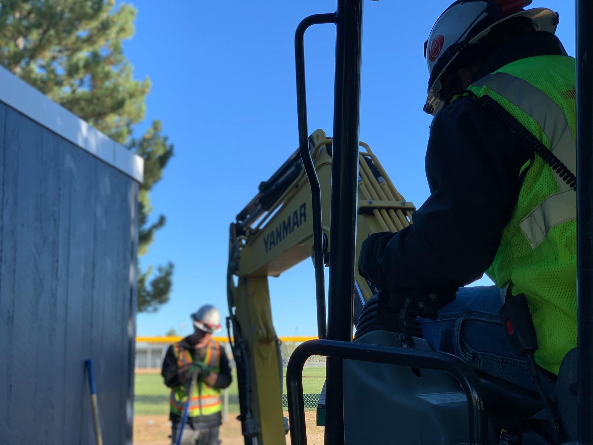 a construction worker is driving an excavator on a construction site .