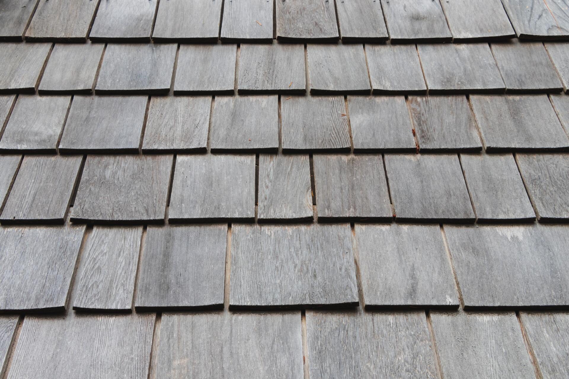 This is a photo of shingles on the roof of a house. A lot of items may land on your roof and wash down to the gutters when it rains, causing clogs.