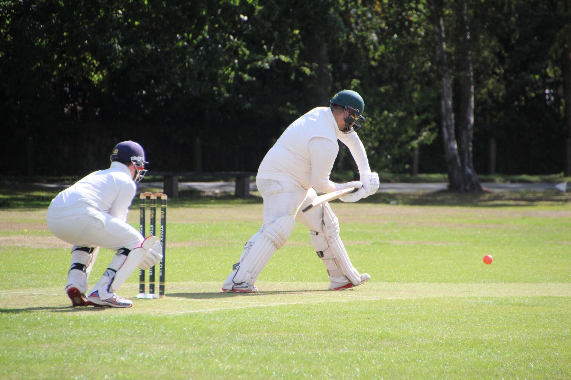 Two cricket players are playing a game of cricket on a field.