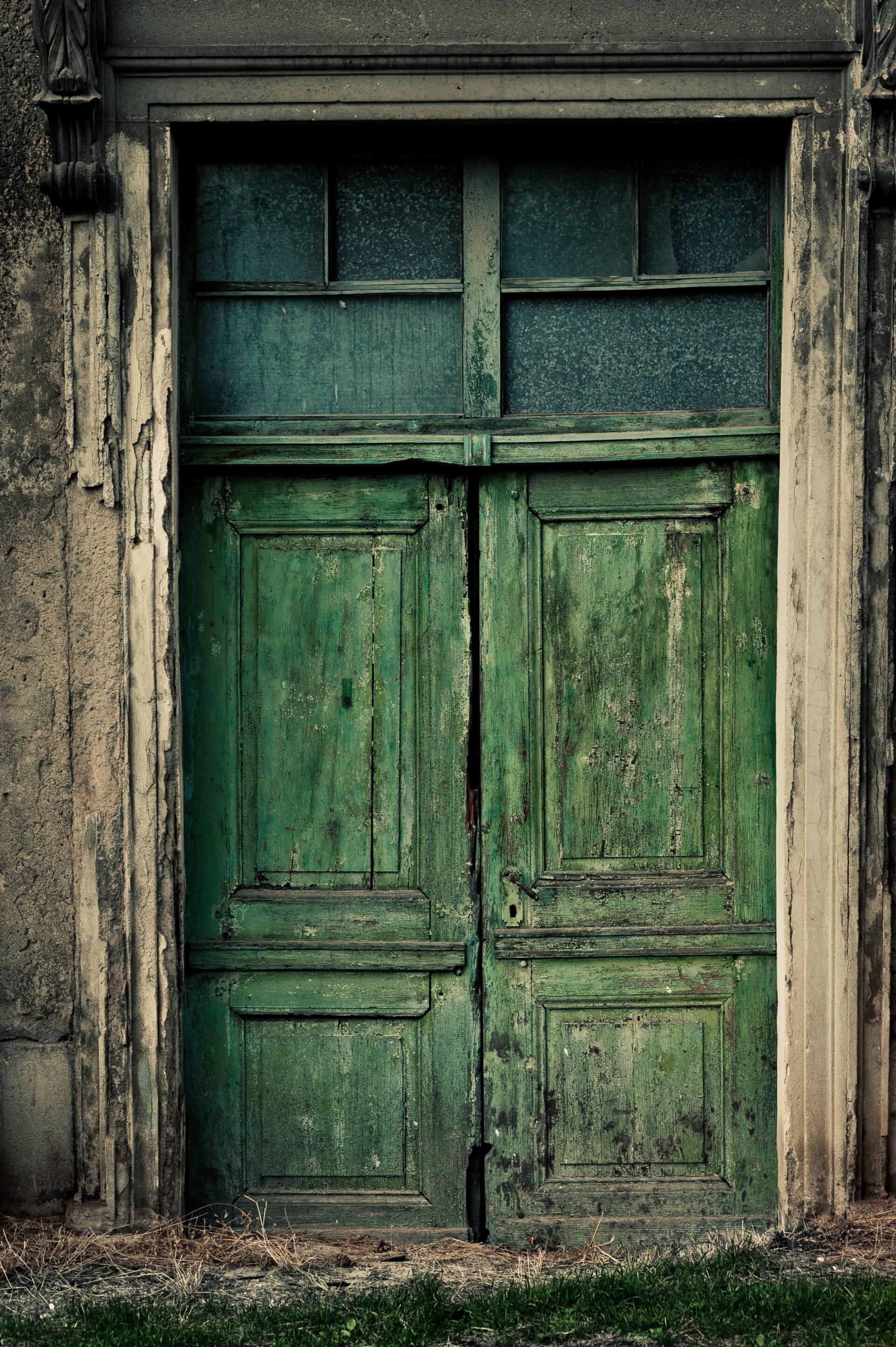 A very old green door with a gray frame