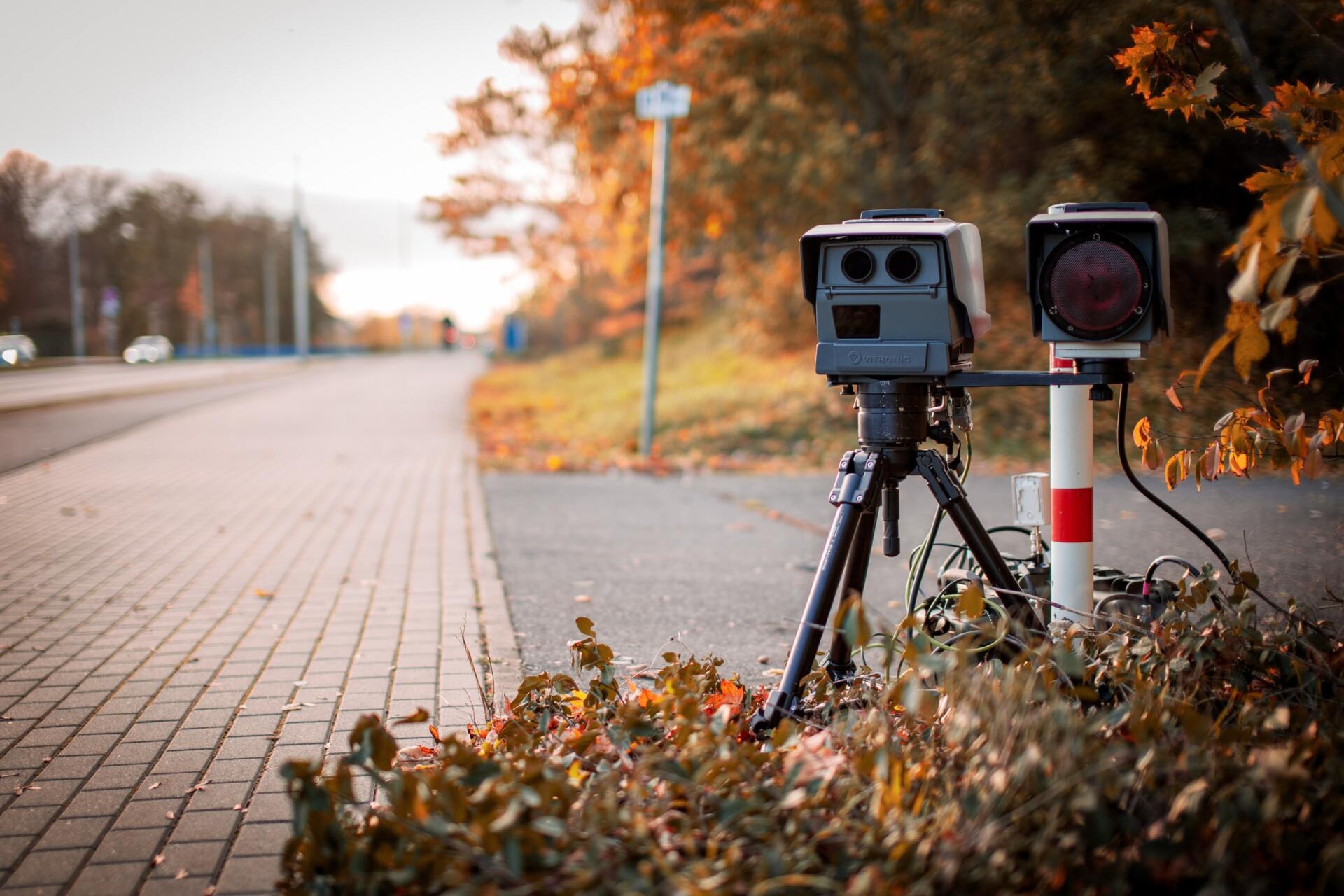 A Speed Camera is Sitting on a Tripod on the Side of the Road — Warland Solicitors in Cardiff, NSW