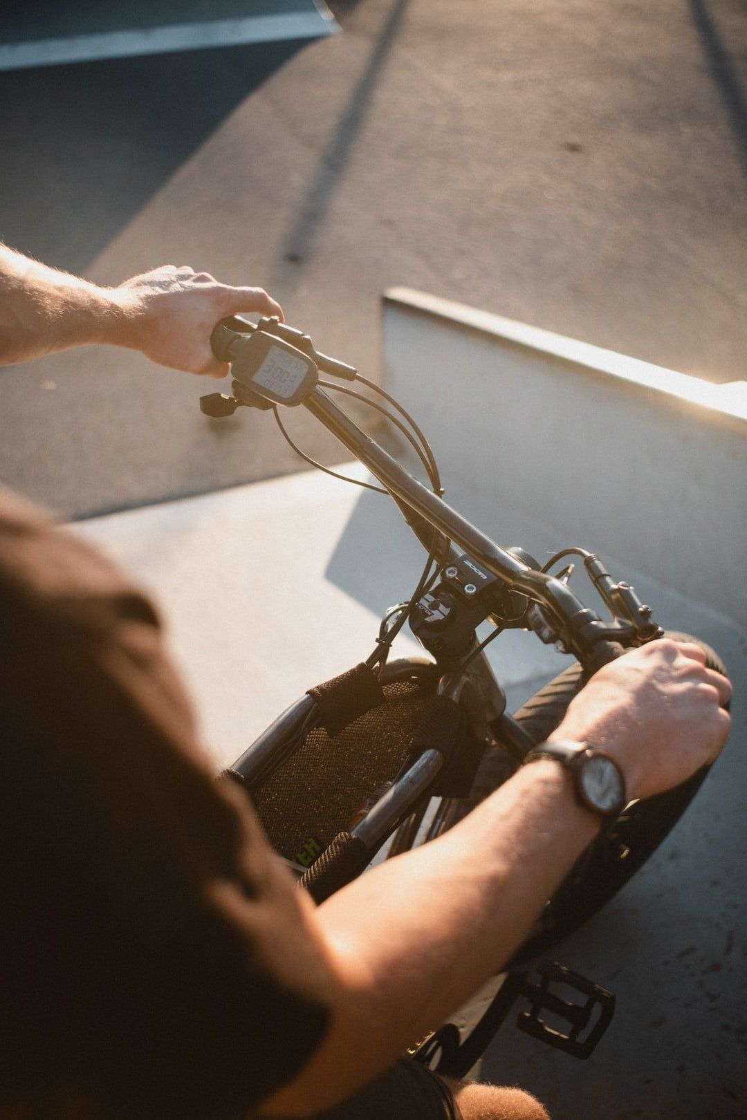 A man wearing a watch is riding an electric bike