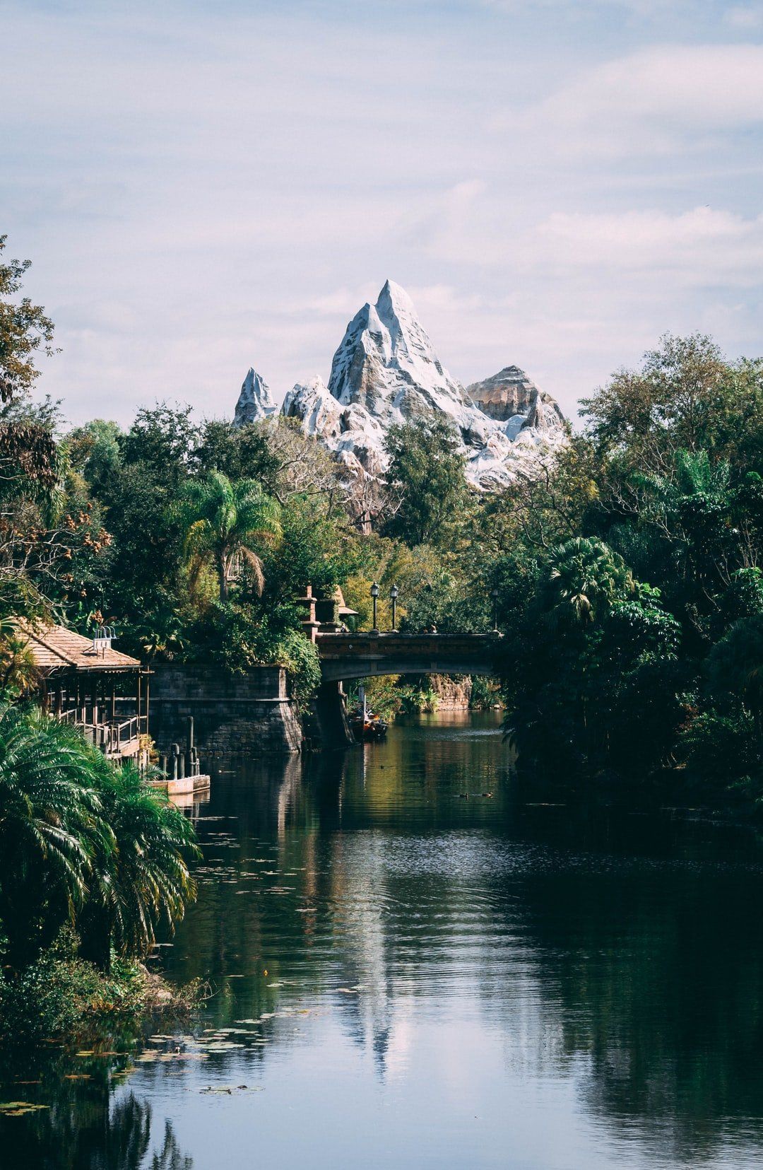 A bridge over a river with a mountain in the background.