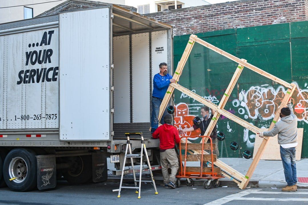 four men moving items out of a large truck