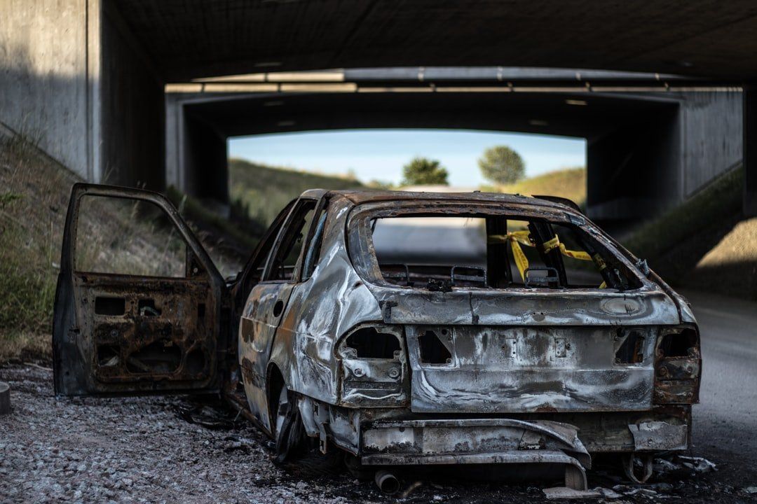 Burnt, beat, abandoned car on side of road