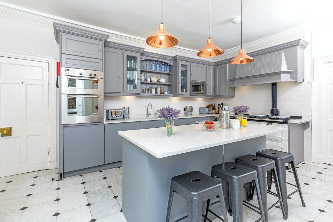 beautiful grey kitchen with black and white diamond floor tiles