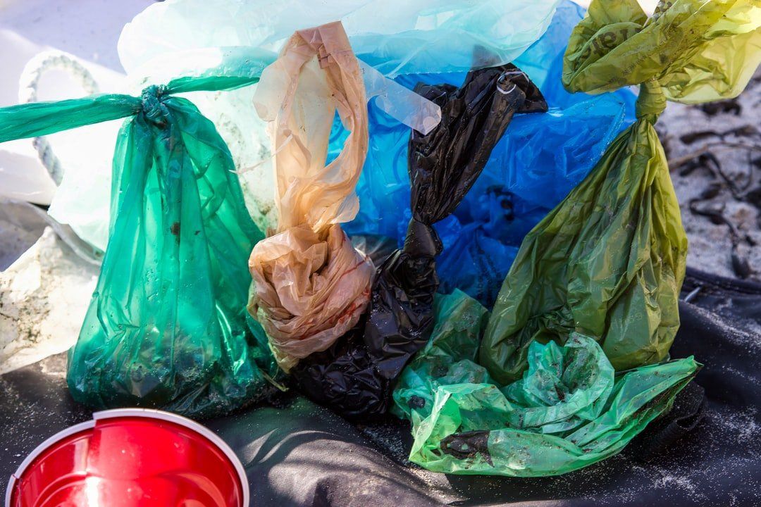 A pile of plastic bags sitting on top of a table next to a red cup.